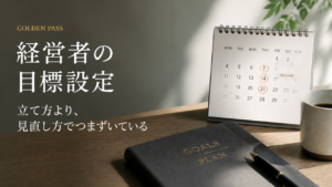 卓上カレンダーの横に置かれた、経営計画の手帳とペン